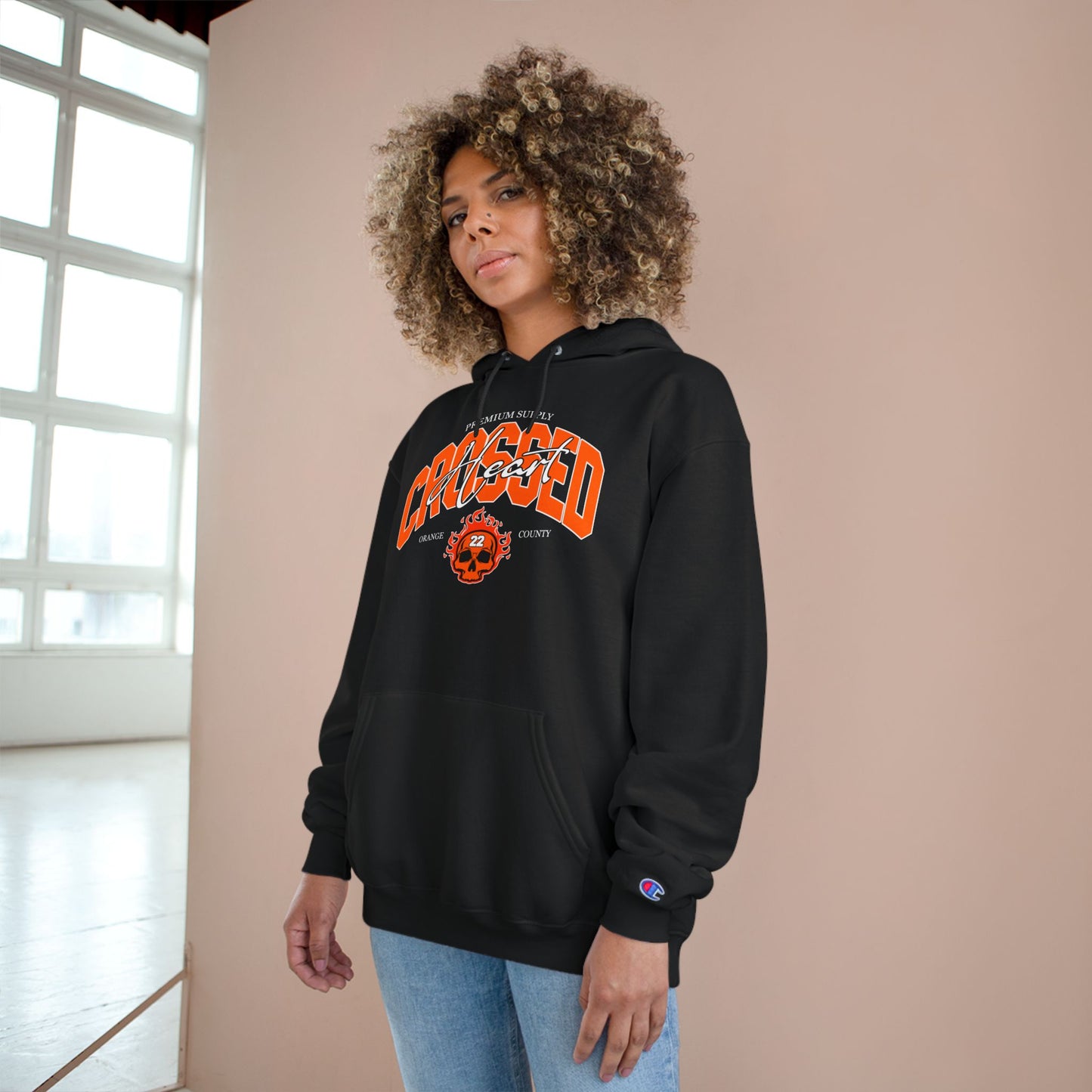 model wearing black chc premium supply champion hoodie with orange county skull graphic front print streetwear lifestyle image