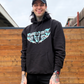 person wearing black hoodie with teal crossed heart lightning logo graphic front print streetwear lifestyle photo