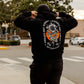 person wearing black crossed not cursed hoodie with rose skeleton graphic back print crossed heart clothing streetwear lifestyle photo