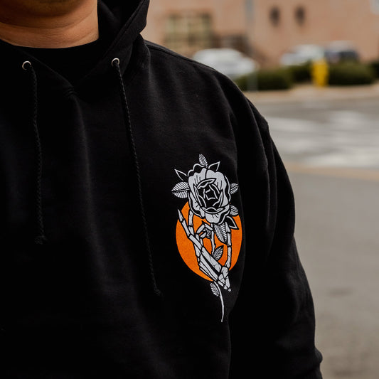 close up of black crossed not cursed hoodie with rose skeleton chest graphic crossed heart clothing streetwear