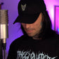 person wearing black lightning heart dad hat with green embroidered heart logo crossed heart clothing streetwear lifestyle photo
