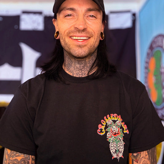 person wearing black graphic t-shirt with traditional tattoo style skull rose illustration front print streetwear lifestyle photo