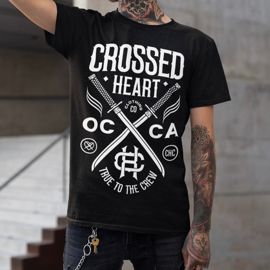 Person wearing black alternative streetwear True To The Crew t-shirt featuring crossed swords logo by Crossed Heart Clothing OC CA