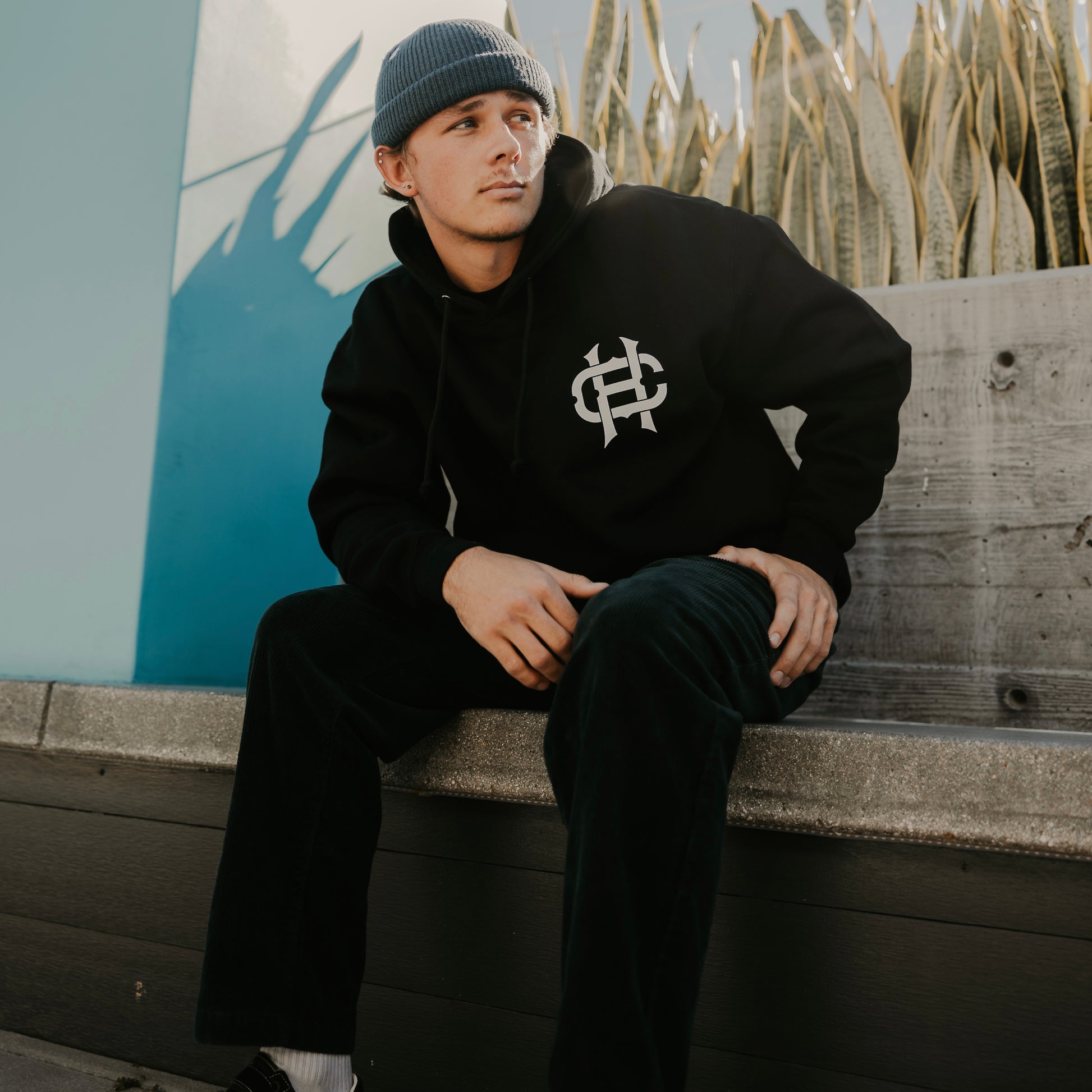person wearing true to the crew crossed heart black hoodie with chest logo tattoo inspired alternative streetwear hoodie front graphic