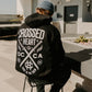 person wearing true to the crew crossed heart black hoodie with oc ca crossed swords graphic tattoo inspired alternative streetwear hoodie outdoors